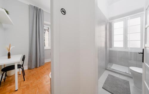 a white bathroom with a table and a toilet at Soar Home l ENTRECAMPOS 3 l Central Comfort Stay, Fast WiFi, Steps to Metro, Near Campo Grande Park in Lisbon