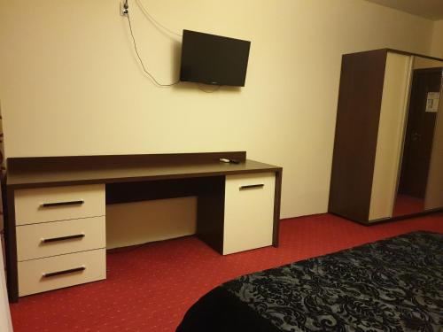 ein Zimmer mit einem Schreibtisch und einem Fernseher an der Wand in der Unterkunft Casa Marly in Caracal
