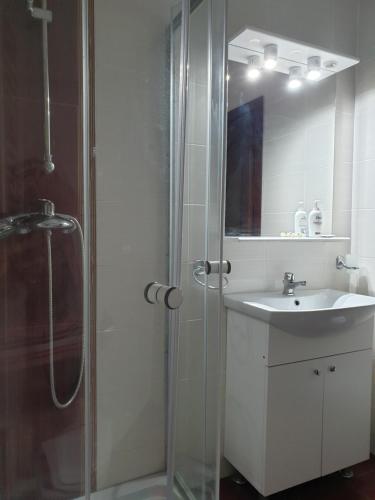 ein weißes Badezimmer mit Waschbecken und Dusche in der Unterkunft Casa Marly in Caracal