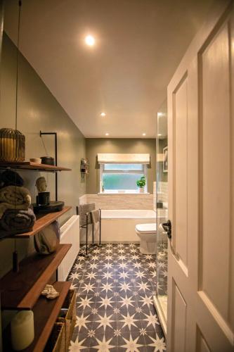 a bathroom with a toilet and a bath tub at Nadder Lodge - Salisbury in Old Sarum