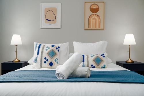 a bed with white sheets and pillows and two lamps at Soar Home l ENTRECAMPOS 3 l Central Comfort Stay, Fast WiFi, Steps to Metro, Near Campo Grande Park in Lisbon