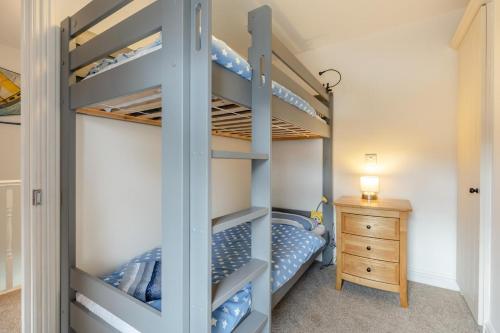 a bedroom with bunk beds with a wooden dresser at 2 Bed in Mundesley oc-1353 in Mundesley