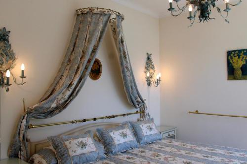 a bedroom with a canopy bed with blue pillows at Barony Le Pergole Lugano Villa for 8 persons in Lugano