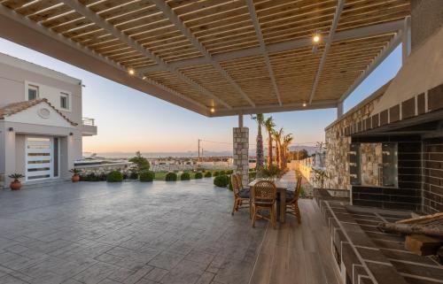 a patio with a table and chairs under awning at Alkis Dream Villa with Jacuzzi in Kos