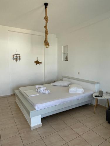 a white bedroom with a bed in a room at Iosub Houses & Studios - Cosy Seaside House in Koumbara in Tzamaria