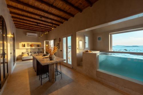 a home with a swimming pool and a kitchen and a table at Legends in Town, by Mykonos High in Mikonos