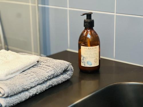 a bottle of alcohol sitting on a counter next to a sink at La tour de Grignan in Grignan