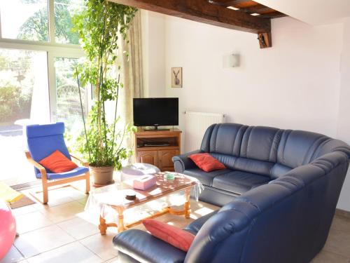 un soggiorno con divano blu e 2 sedie di Rural lodging located in the small village of Radelange 100 Nature a Radelange