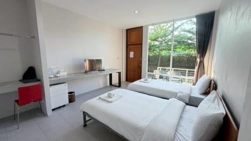 a hotel room with two beds and a window at Woodview Resort in Samut Prakan