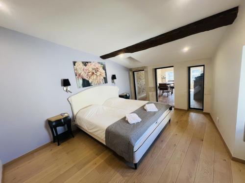 a bedroom with a large bed and a wooden floor at La tour de Grignan in Grignan