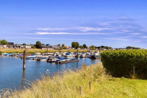 a bunch of boats are docked in a river at Bell Tent aan de haven in Heerewaarden