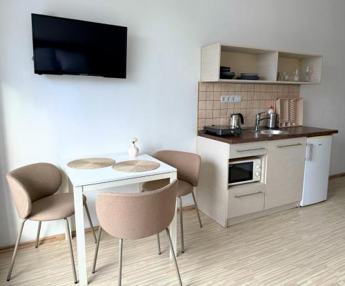 a small kitchen with a small table and chairs at ZOOM Apartments - Budapest in Budapest