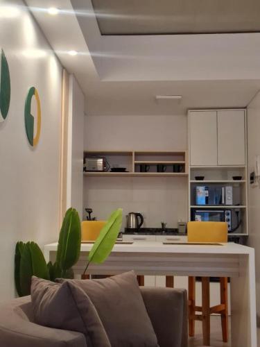 a living room with a table and a kitchen at Toscana Apart in San Miguel de Tucumán