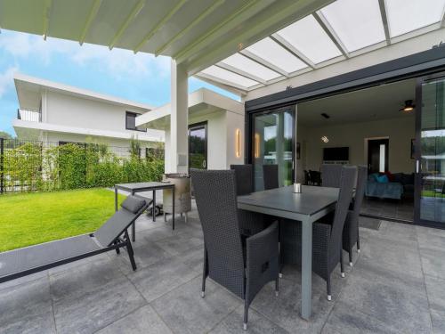 a patio with a table and chairs on a patio at Harderwold Villa Resort in Zeewolde