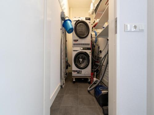 a hallway with two washing machines in a room at Harderwold Villa Resort in Zeewolde