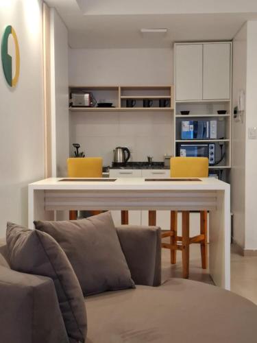 a kitchen with a table and yellow chairs in a room at Toscana Apart in San Miguel de Tucumán