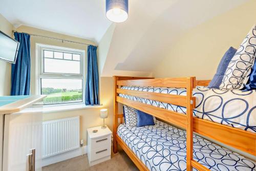 a bedroom with a bunk bed and a window at 3 Bed in Woolacombe oc-clevel in Woolacombe