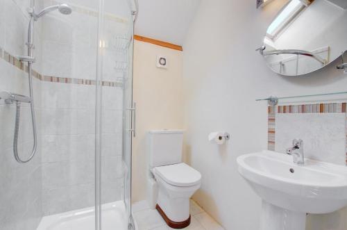 a bathroom with a toilet and a sink and a shower at 3 Bed in Tiverton oc-thresh in Bampton