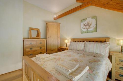 a bedroom with a large bed with a wooden frame at 3 Bed in Tiverton oc-thresh in Bampton