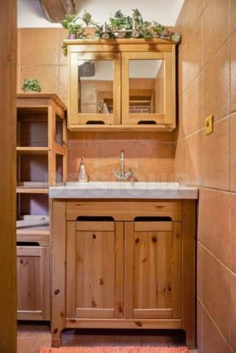 a kitchen with wooden cabinets and a sink at Chalupa Dolní Hedeč blízko Dolní Moravy in Horní Orlice
