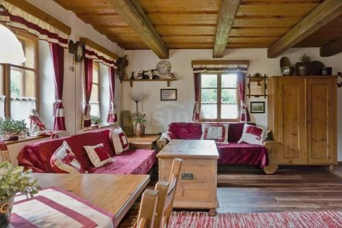 a living room with red couches and a table at Chalupa Dolní Hedeč blízko Dolní Moravy in Horní Orlice