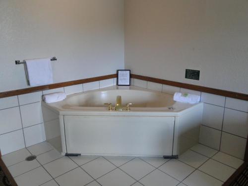 a bath tub in a bathroom with a sink at Oscoda Lakeside Hotel in Oscoda