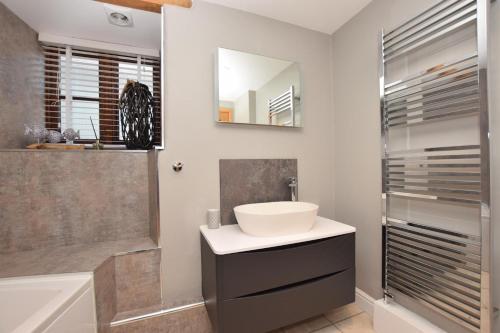 a bathroom with a sink and a tub and a mirror at 2 Bed in Braunton oc-stabb in Braunton