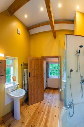 a bathroom with yellow walls and a sink and a shower at 2 Bed in Lynton oc-trelyn in Lynmouth
