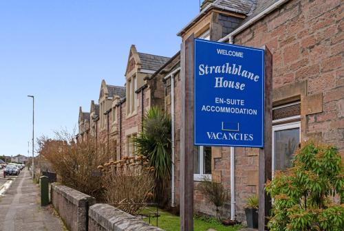 a blue street sign in front of a house at mySTAYINN Strathblane House in Inverness