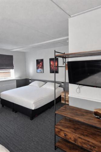 a bedroom with a bed and a flat screen tv at Hotel,cafe,biljart POT in Groenlo