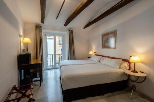 a hotel room with a bed and a balcony at Hotel Simon in Seville