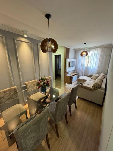 a living room with a glass table and chairs at Casa Matteucci 2 quartos in Londrina