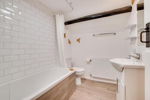 a bathroom with a tub and a toilet and a sink at 1 Bed in Parracombe oc-smitho in Trentishoe