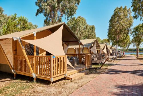 a row of wooden huts in a row at Glamping at Sardinia in Alghero