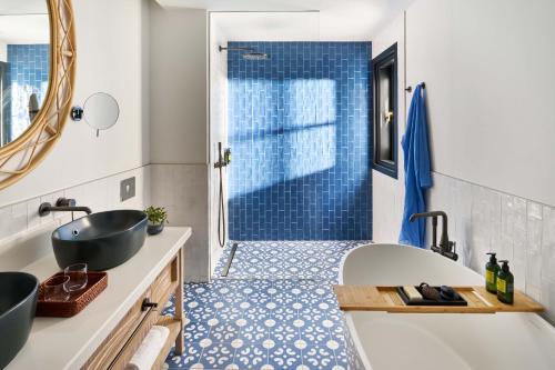 a bathroom with a tub and a sink and a shower at Seaside Los Jameos in Puerto del Carmen
