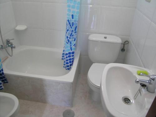a bathroom with a white toilet and a sink at Casa Bruna 1º A Apartamento a 800 m de la playa in Lariño