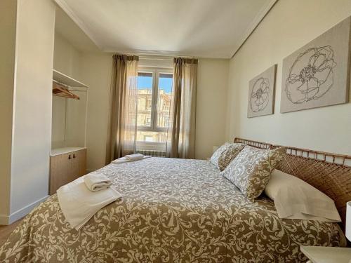 a bedroom with a bed and a window at Espacios Blanco Santiago in Valladolid