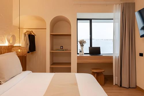 a bedroom with a bed and a desk and a window at 2Luxury Provenza: Htd Pool, Jacuzzi, BBQ, Pool in Medellín