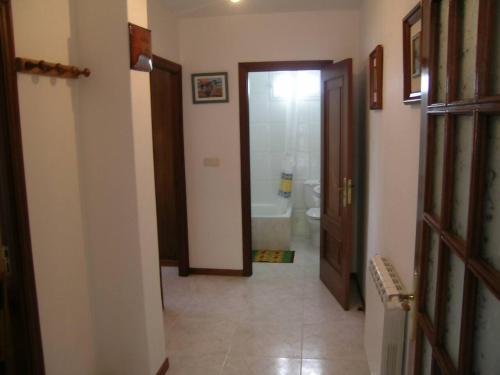 a hallway with a bathroom with a toilet and a door at Casa Bruna Baixo A Apartamento a 800 m de la playa in Lariño