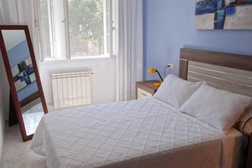 a bedroom with a bed and a mirror and a window at Casa Bruna Baixo A Apartamento a 800 m de la playa in Lariño