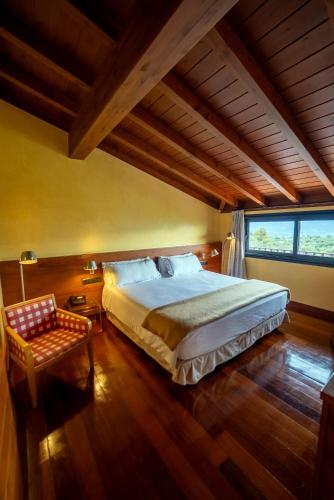 a bedroom with a large bed and a chair at Montanyà in Seva