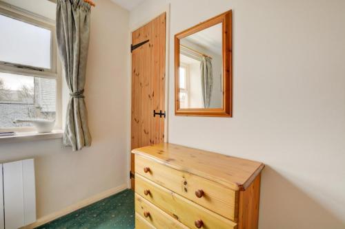 a bedroom with a wooden dresser and a mirror at 2 Bed in Leyburn oc-ds902 in Askrigg