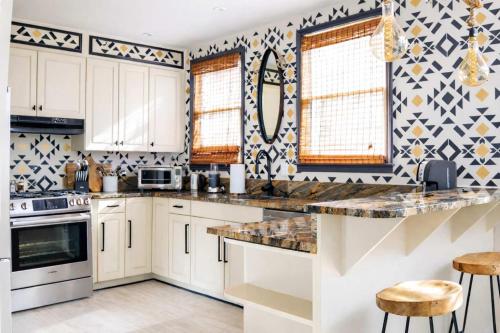 a kitchen with white cabinets and black and white tiles at Boho Lux in Atlanta