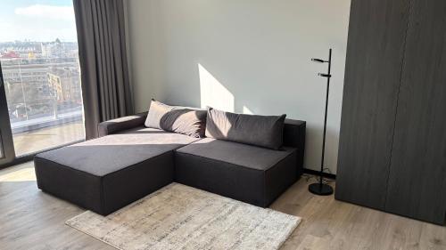 a couch in a living room with a large window at Bavaro apartments 2 in Ivano-Frankivsk