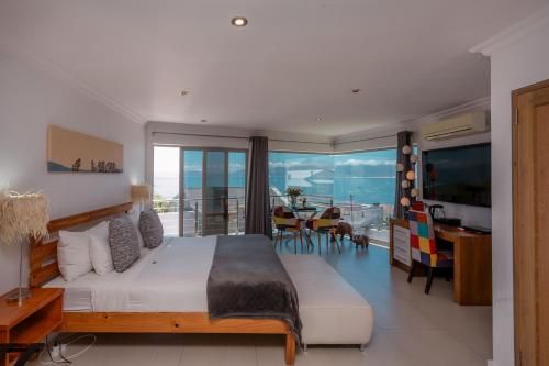 a bedroom with a large bed and a view of the ocean at Sea Star Lodge in Gansbaai