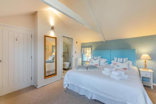 a bedroom with a large white bed and a bathroom at 2 Bed in Bamburgh oc-gd1165 in Bamburgh