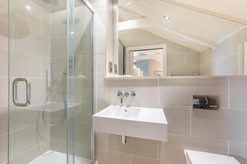 a white bathroom with a sink and a shower at 2 Bed in Bamburgh oc-gd1165 in Bamburgh