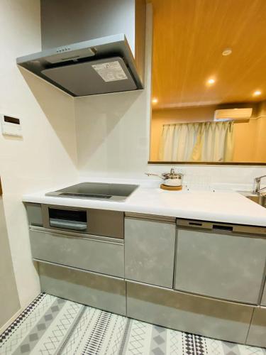 a kitchen with a sink and a stove at Villa KENZO JR弁天町駅4分地下鉄駅6分 USJ 梅田 大阪城公園直通 駐車場付きモダン一軒家 in Osaka