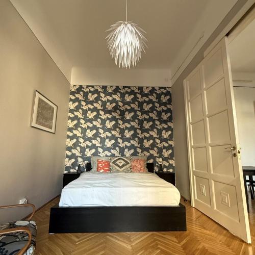 a bedroom with a white bed and a chandelier at Raday Bobo in Budapest