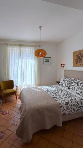a bedroom with a large bed and a chair at Agrodolce B&B in Cefalù
